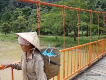 Mujer cruzando el puente a cueva de Tham Jang
