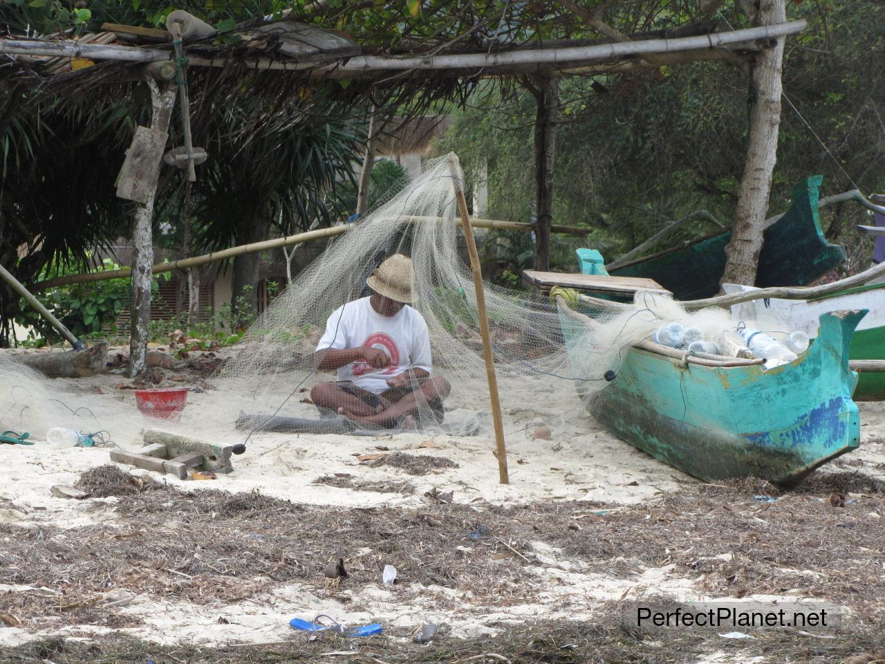 Fishermen repairing his nets